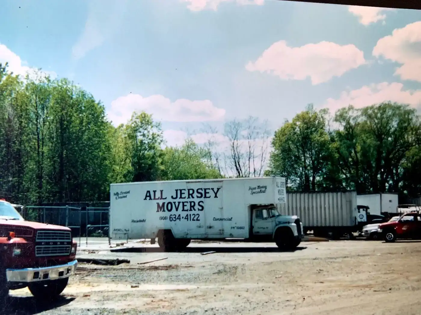 A white moving truck from All Jersey Movers is standing in the parking